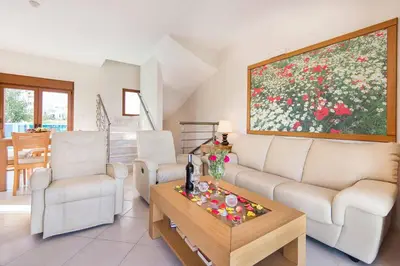 a living room with a couch and chairs and a painting at Villa Kiotari Alia in Kiotari
