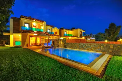 a villa with a swimming pool in front of a house at Villa Kiotari Alia in Kiotari