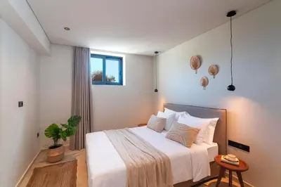 a bedroom with a bed with white sheets and pillows at Massari Hills Luxury Living in Malona Village
