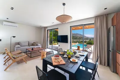 a dining room and living room with a table and chairs at Massari Hills Luxury Living in Malona Village