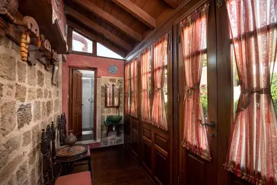 a hallway of a house with red curtains on the windows at Mythic Spa Villa in Rhodes Town