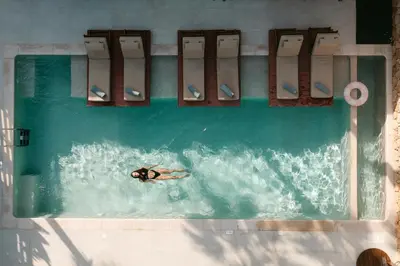 a person in a pool with surfboards in the water at STALèA Luxury Villa in Pefki Rhodes