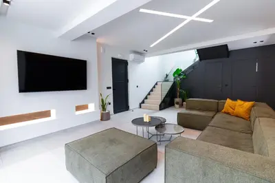 a living room with a couch and a tv on a wall at STALèA Luxury Villa in Pefki Rhodes