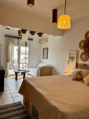 a bedroom with a large bed and a table at ALONI G&A Archaggelos in Archangelos