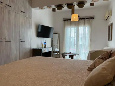 a bedroom with a bed and a flat screen tv at ALONI G&A Archaggelos in Archangelos