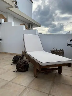 a white bed sitting on top of a balcony at ALONI G&A Archaggelos in Archangelos