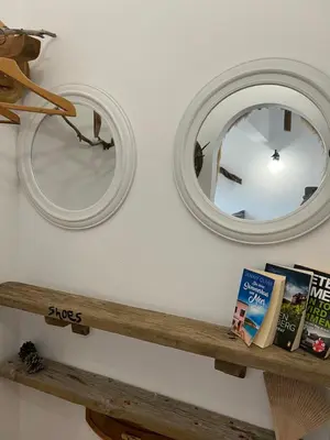 two mirrors on a wall next to a wooden shelf at ALONI G&A Archaggelos in Archangelos