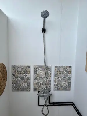 a shower in a room with four tiles on the wall at ALONI G&A Archaggelos in Archangelos