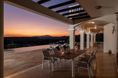 a dining table and chairs on the roof of a house at Villa Kamos in Archangelos