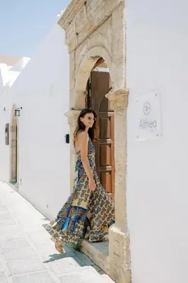 a woman in a dress standing outside a door at Althea Villa in Líndos