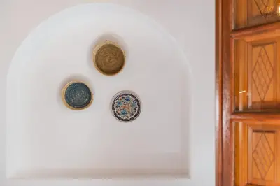 two plates on a wall next to a door at Althea Villa in Líndos