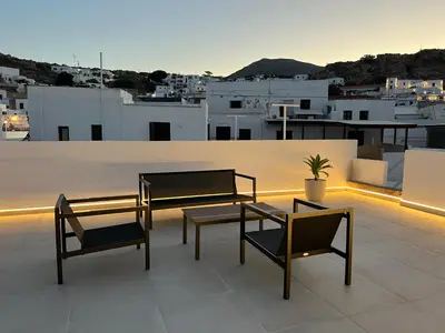 a patio with two chairs and a table on a roof at Althea Villa in Líndos