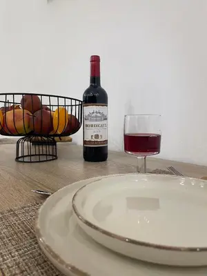 a bottle of wine next to a plate and a wine glass at Villa Flora in Afantou
