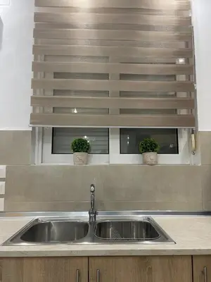 a kitchen sink with two potted plants on a ledge at Villa Flora in Afantou
