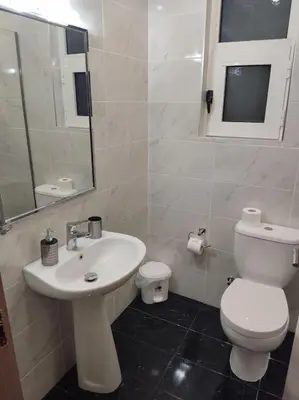 a bathroom with a white toilet and a sink at Villa Flora in Afantou
