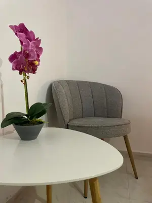 a chair and a white table with a flower on it at Villa Flora in Afantou