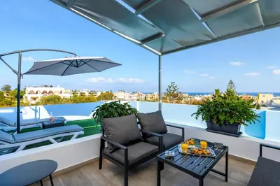 a balcony with a table and chairs and a boat at Sky High Loft in Rhodes Town