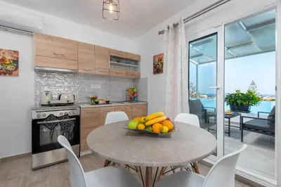 a kitchen with a table with a bowl of fruit on it at Sky High Loft in Rhodes Town