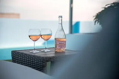 a bottle of wine and two glasses on a table at Sky High Loft in Rhodes Town