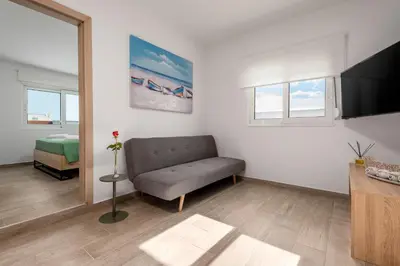 a living room with a couch and a television at Sky High Loft in Rhodes Town
