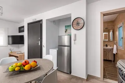 a kitchen with a table with a bowl of fruit on it at Sky High Loft in Rhodes Town