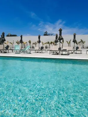a pool of water with chairs and tables in the background at FRESH HOTEL FALIRAKI in Faliraki
