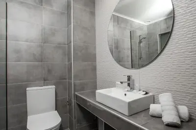 a bathroom with a toilet and a sink and a mirror at FRESH HOTEL FALIRAKI in Faliraki