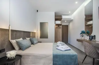 a bedroom with a bed and a table and a chair at FRESH HOTEL FALIRAKI in Faliraki