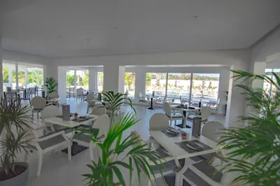a restaurant with tables and chairs and plants at FRESH HOTEL FALIRAKI in Faliraki