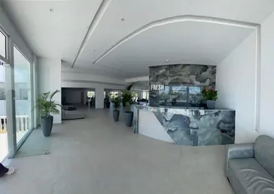 a living room with a lobby with a stone fireplace at FRESH HOTEL FALIRAKI in Faliraki