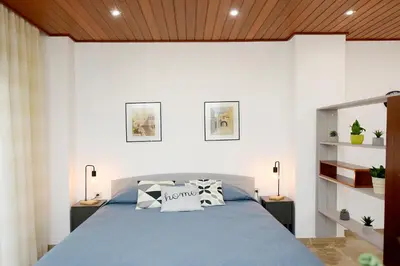 a bedroom with a blue bed and white walls at Martha's Home in Rhodes Town