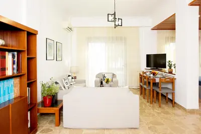 a living room with a white table and a tv at Martha's Home in Rhodes Town