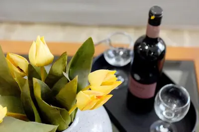 a bottle of wine and a vase with flowers on a table at Martha's Home in Rhodes Town