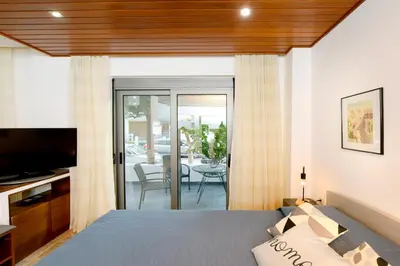 a bedroom with a bed and a television and a patio at Martha's Home in Rhodes Town
