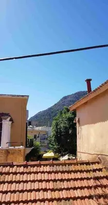 a view of a house with a mountain in the background at Irene's Apartment In Salakos in Sálakos