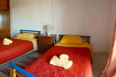 two beds in a room with red and yellow at Irene's Apartment In Salakos in Sálakos