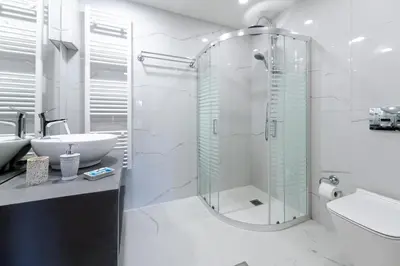 a bathroom with a glass shower and a sink at Island Rodos Pool Suites in Ialyssos