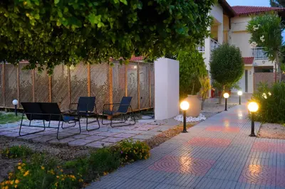 a patio with chairs and lights next to a building at Island Rodos Pool Suites in Ialyssos