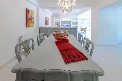 a white dining room table with a red table cloth at Island Rodos Pool Suites in Ialyssos