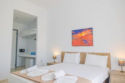 a bedroom with a large white bed with towels on it at Viva Tourismo Resort (naturist club) in Paradeísion