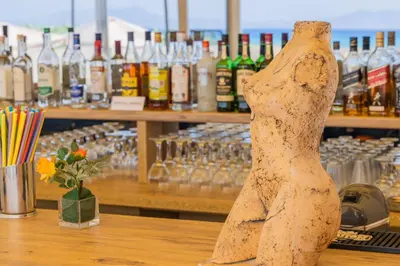 a wooden mannequin sitting on a counter in a bar at Viva Tourismo Resort (naturist club) in Paradeísion