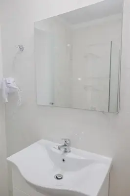 a bathroom with a white sink and a mirror at Viva Tourismo Resort (naturist club) in Paradeísion