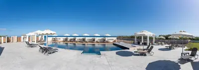 a pool with chairs and umbrellas on a patio at Viva Tourismo Resort (naturist club) in Paradeísion