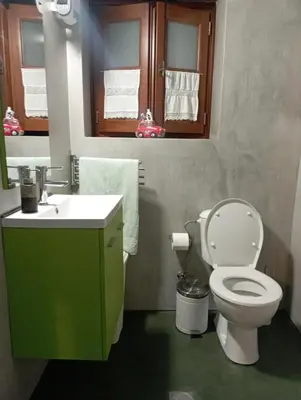 a bathroom with a green sink and a toilet at STONE GUESTHOUSE in Áyios Isídhoros