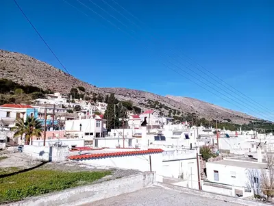 a view of a town with white buildings and mountains at STONE GUESTHOUSE in Áyios Isídhoros