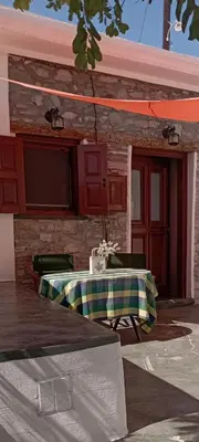 a table sitting in front of a house at STONE GUESTHOUSE in Áyios Isídhoros