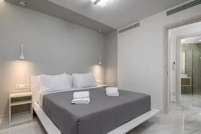 a white bedroom with a bed with two towels on it at Panorama Luxury Penthouse in Ixia