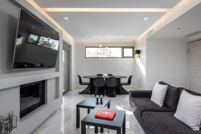 a living room with a couch and a table at Panorama Luxury Penthouse in Ixia