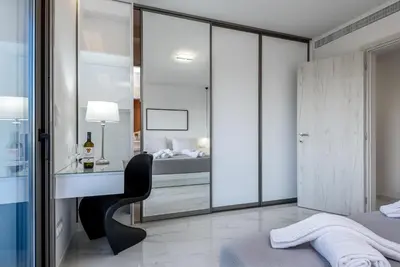 a bedroom with a bed and a desk with a chair at Panorama Luxury Penthouse in Ixia