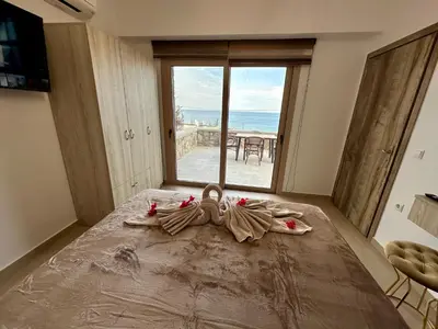 a bedroom with a bed with a view of the ocean at Anemos Villa Stegna in Archangelos